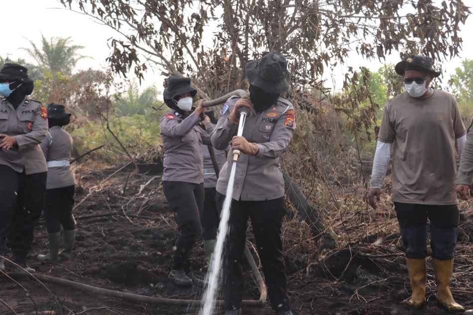 Di Tengah Kepungan Asap, Srikandi Polres Kampar Tampil di Garis Depan Padamkan Karhutla
